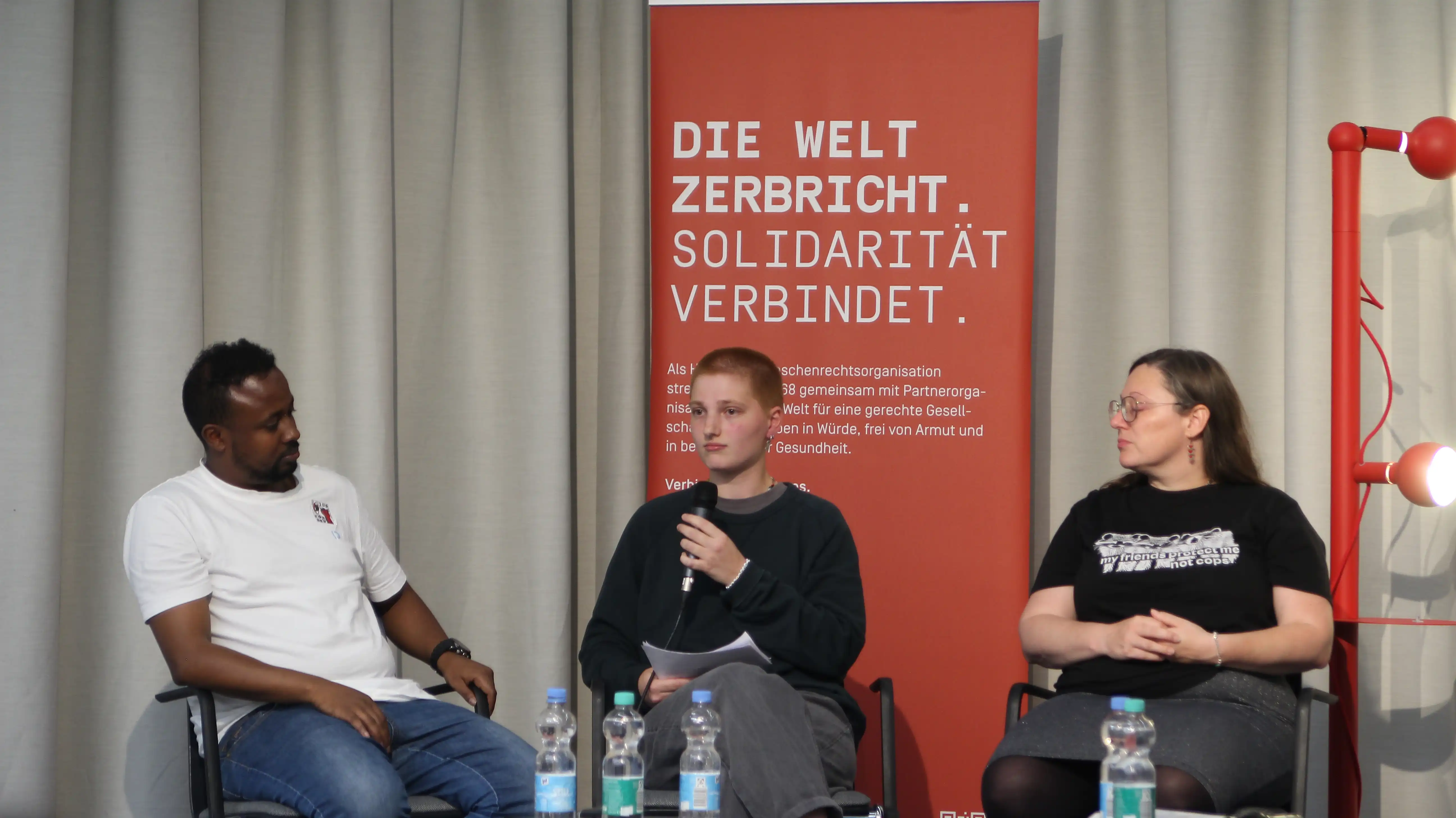 Von links nach rechts: Kamal und Klee die ins Mikro spricht, Michelé